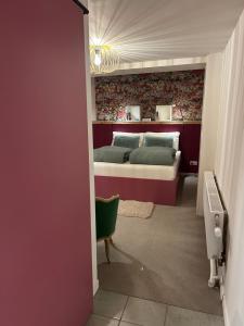 a bedroom with a bed and a red wall at Chez Gaston in Spa +7 photos