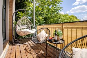 a porch with two wicker chairs and a table at EDLER WOHNRAUM Design-Loft im Graphischen Viertel 2 Schlafzimmer mit Balkon, Miele-Kaffeevollautomat, Miele-Weinkühler, Klima, Lift, Tiefgarage & WLAN 266 Mbps in Leipzig