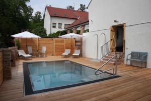 ein Swimmingpool auf einer Holzterrasse neben einem Haus in der Unterkunft Hotel Lechowitz in Lechwitz
