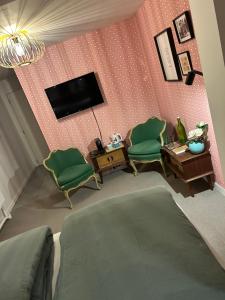 a living room with a tv and two green chairs at Chez Gaston in Spa