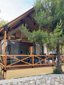 a house with a large deck with a tree at Luna Glamping de Luxe in Drage