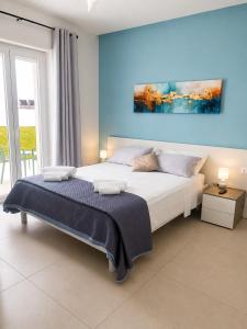 a bedroom with a large bed with a blue wall at SottoSopra Tropea in Tropea
