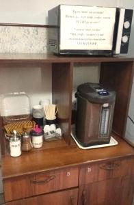 a microwave sitting on top of a kitchen shelf at Гостиница Роза in Almaty