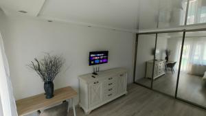 a living room with a tv and a mirror at Mirdzas Ķempes iela 14 in Liepāja