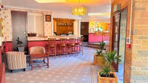 a bar in a restaurant with chairs and a counter at The Columbia Hotel in Wellingborough