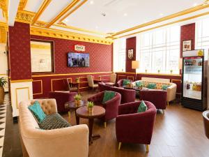 a waiting room with couches and chairs and tables at The Malik - An Art Deco Hotel in Birmingham