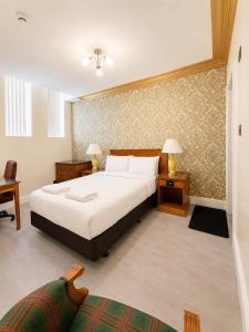 a bedroom with a large white bed and a desk at The Malik - An Art Deco Hotel in Birmingham +11 photos