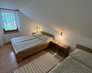 a bedroom with two beds and a window at Chata Biely Potok in Oravský Biely Potok
