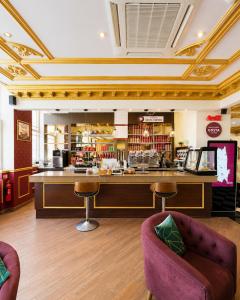 a restaurant with a counter with stools and a bar at The Malik - An Art Deco Hotel in Birmingham
