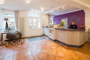 a woman standing at the counter of a salon at Flair Hotel Rieckmann in Bispingen