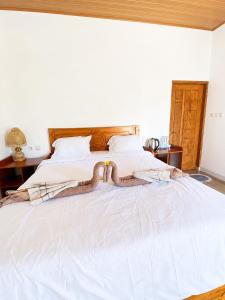 a bed with a snake laying on top of it at Eleen Bungalow in Tetebatu