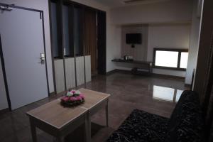 a living room with a table with flowers on it at PLA RESIDENCY Trichy near Rockfort Temple in Tiruchirappalli