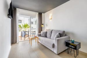 a living room with a couch and a table at Apartamentos Vibra Jabeque Dreams in Ibiza Town