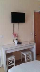 a white desk with a television on a wall at Hotel André Gill in Paris