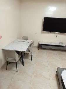 a dining room with a table and chairs and a flat screen tv at Bbimo in Dakar