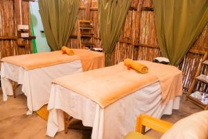 two tables in a room with green curtains at Sea View Lodge Boutique Hotel in Jambiani