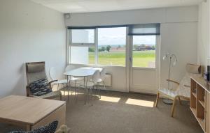 a living room with a table and chairs and a window at Pet Friendly Apartment In Allinge in Allinge