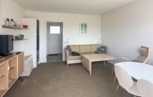 a living room with a couch and a table at Pet Friendly Apartment In Allinge in Allinge