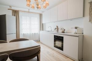 a kitchen with white cabinets and a table and a stove at Boho - Suites I BRIGHT-Collection in Koblenz