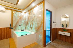 a bathroom with a tub and a shower at Emmanuel Residency in Edappally