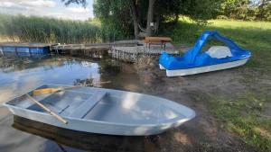 a blue boat sitting on the water next to a playground at Zacisze Mrozy in Ełk