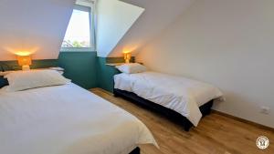 a bedroom with two beds and a window at Le Petit Vigneron in Nuits-Saint-Georges