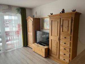 a living room with a tv and a entertainment center at FeWo bei Charly in Herrischried