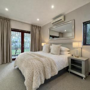 a bedroom with a large bed and a mirror at Oak & Ivory - Uitzicht in Oakdale