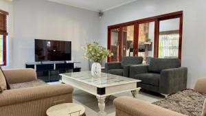a living room with chairs and a table and a tv at Oak & Ivory - Uitzicht in Oakdale