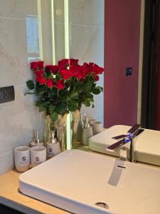 a bathroom sink with red roses in a mirror at Sky Love Hotel - Trâu Qùy in Thạch Cầu +12 photos