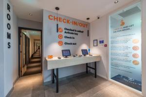a reception desk in a office with a check in counter at Fox Hotel The Hague Scheveningen in Scheveningen
