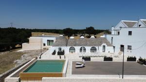 a house with a swimming pool next to a building at Masseria Calandrella in Noci