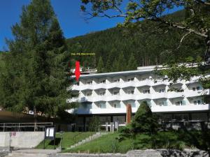 ein großes weißes Gebäude mit einem roten Schild darauf in der Unterkunft Haus Zervreila in Vals