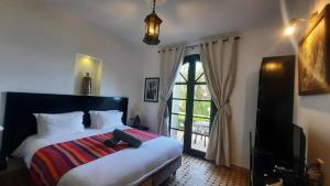 a bedroom with a bed and a large window at Auberge Dar Najmat in Mirleft