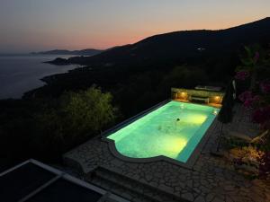 an outdoor swimming pool with a view of the ocean at villa amouso in Évyiros