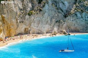 a boat on a beach with a group of people at villa amouso in Évyiros