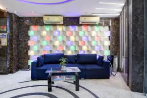 a living room with a blue couch and a table at Townhouse Deshapriya Park Kolkata Formerly DK Inn in Kolkata