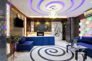 a lobby with a blue table and a chandelier at Townhouse Deshapriya Park Kolkata Formerly DK Inn in Kolkata
