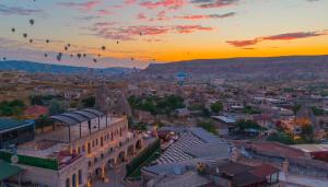 a group of hot air balloons flying over a city at Cappadocia Inn Cave Hotel in Göreme