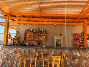 a bar with chairs and a counter with a kitchen at Bonanza beach camp in Nuweiba