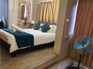 a bedroom with a bed with a fan and a window at The Crooked Forest in Pretoria