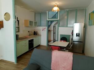 a kitchen with a couch and a table and a refrigerator at Maison T3 - Hypercentre historique - WIFI in Villefranche-de-Rouergue