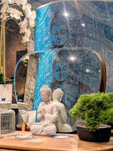 a statue of a woman sitting on a table in front of a wall at Les suites du Bouddha Bleu in Carnac +78 photos