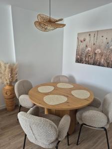 a dining room with a wooden table and chairs at Apartament HARMONY in Koszalin
