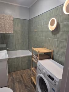 a laundry room with a washing machine and a tub at Apartament HARMONY in Koszalin +3 photos