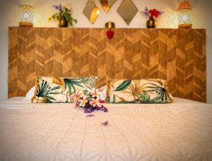 a bed with two pillows and flowers on it at Le Vacoa in La Saline les Bains