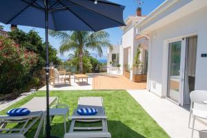 a patio with a table and chairs and an umbrella at Novaeos Sicily in Terrasini