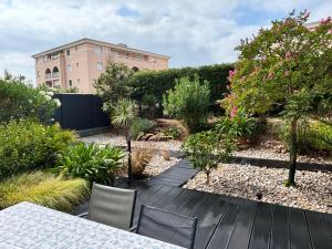 a garden with a table and chairs and a building at Les Enganes in Fréjus