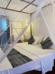 a bedroom with a bed with white mosquito netting at Sky Mountain Café with seaview in Weligama