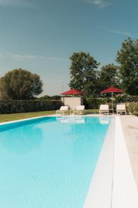 a swimming pool with chairs and umbrellas at PALAZZO RUBINO Aparthotel in Olbia
